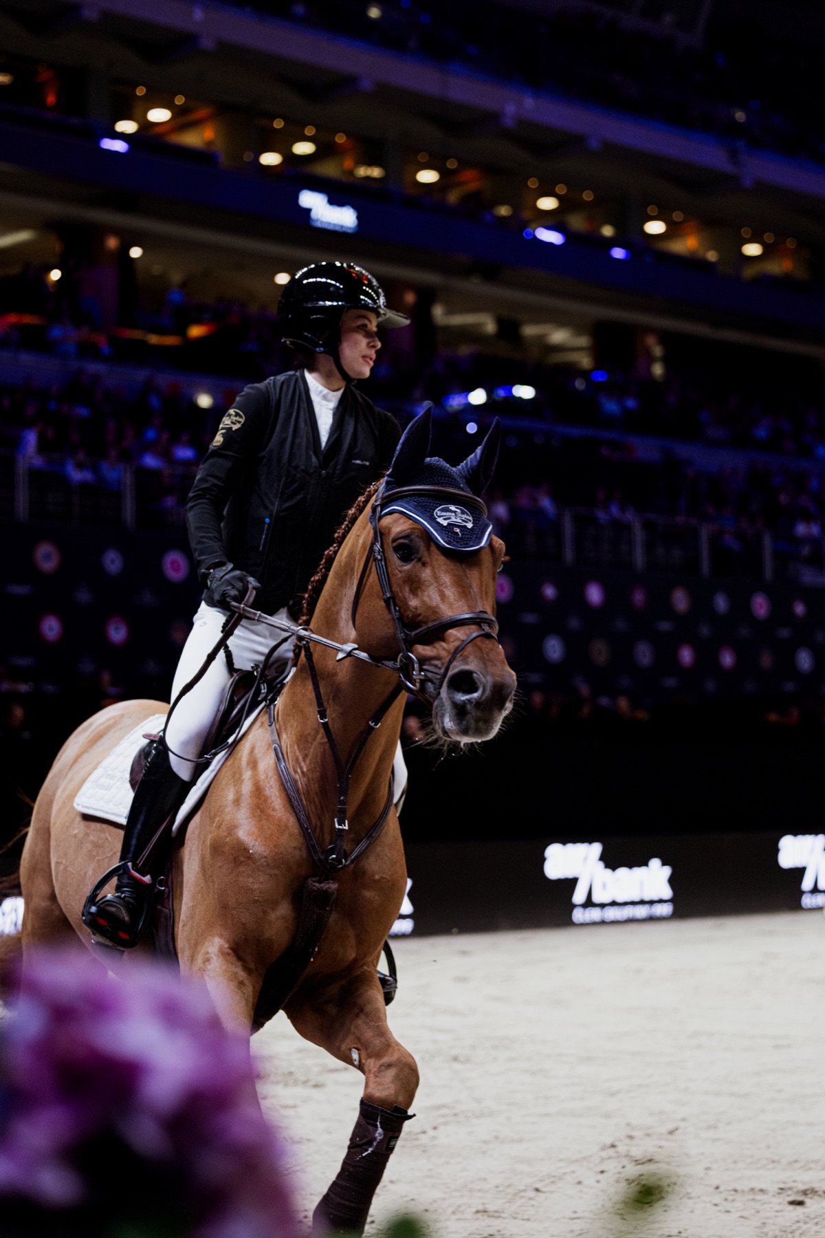 Emma Sophia Španko on horseback in the arena, wearing an Emma Sophia branded ear bonnet