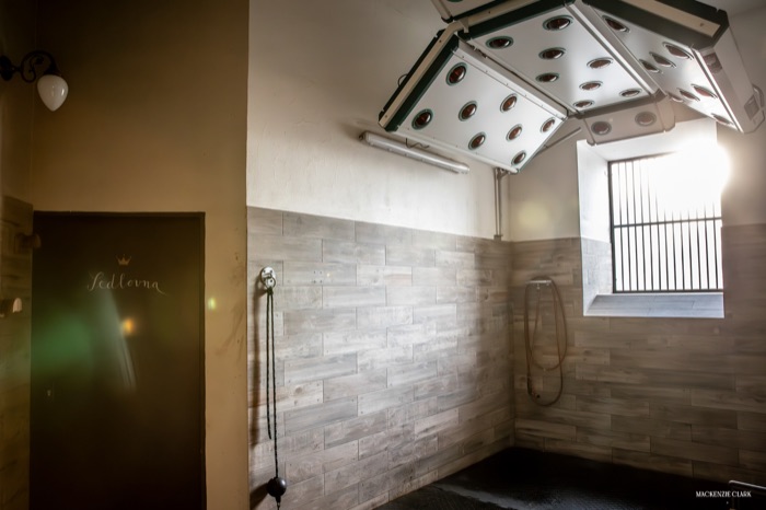 A shower stall fitted with an overhead solarium lamp