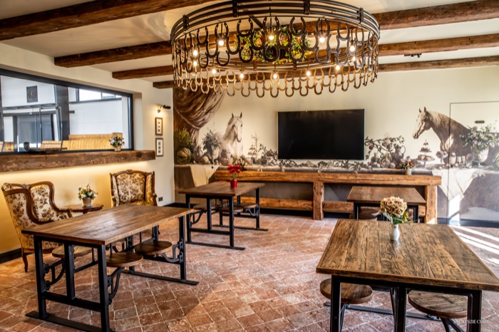 The clubhouse lounge, with a horseshoe chandelier and equestrian murals