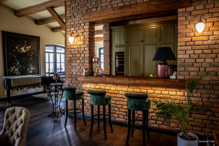 The clubhouse bar, finished in exposed brick with green velvet stools