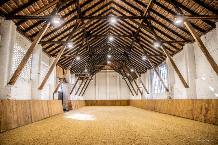 The indoor arena, empty beneath its timber trusses